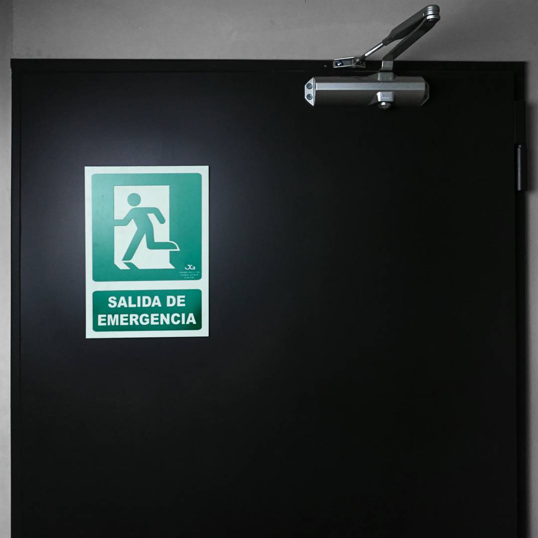 Emergency exit sign to the left. Luminescent signal 21 x 30 cm