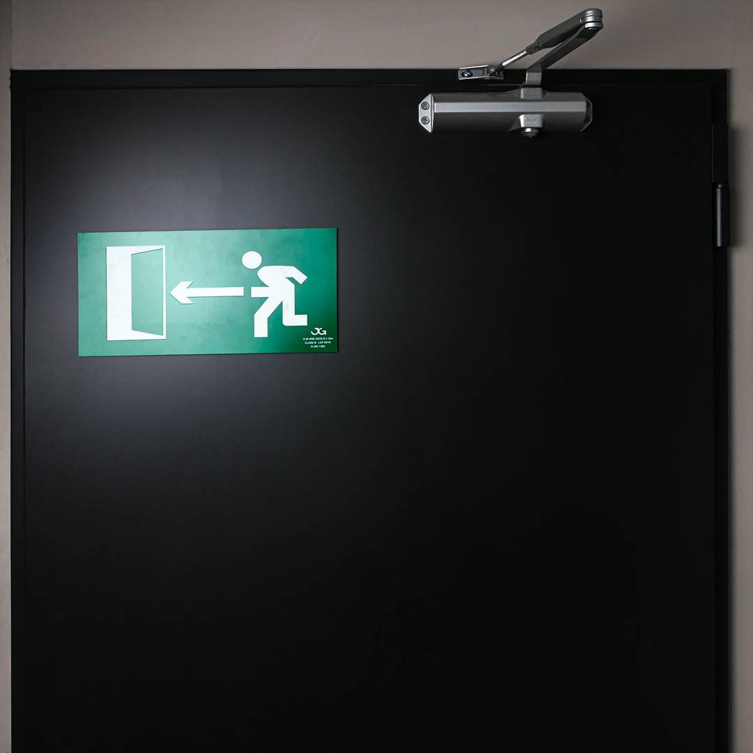 Emergency exit sign to the left. Luminescent signal 32 x 16 cm